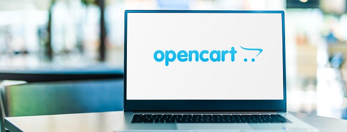 A laptop kept on a table displaying the logo of OpenCart.